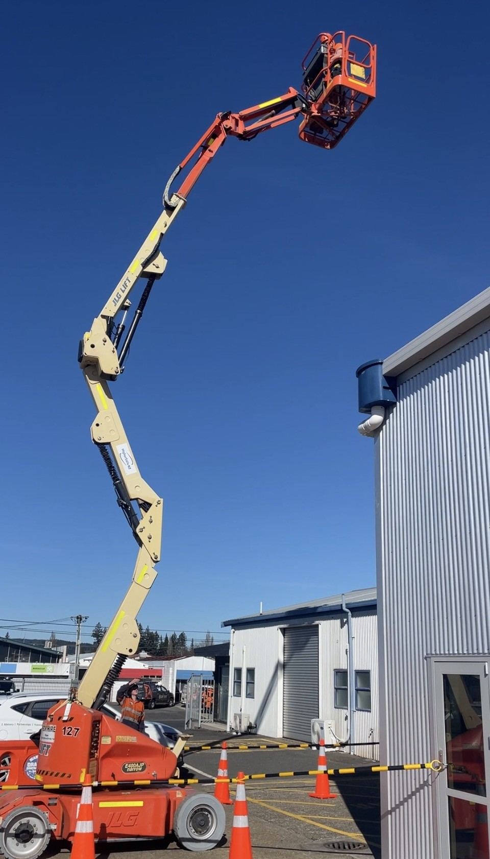 MEWP boom lift reaching over a building